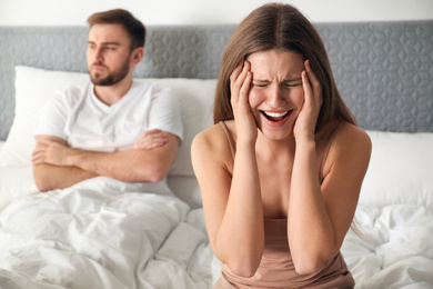 Photo of Unhappy couple with relationship problems after quarrel in bedroom