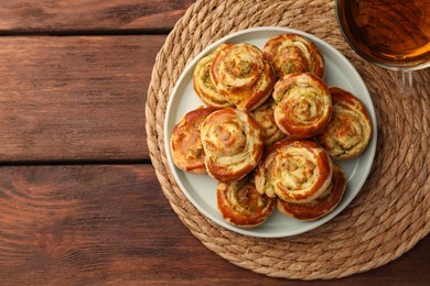 Fresh delicious puff pastry served with tea on wooden table, flat lay. Space for text