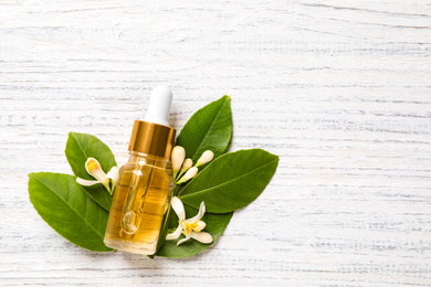 Photo of Flat lay composition with bottle of citrus essential oil on white wooden background. Space for text