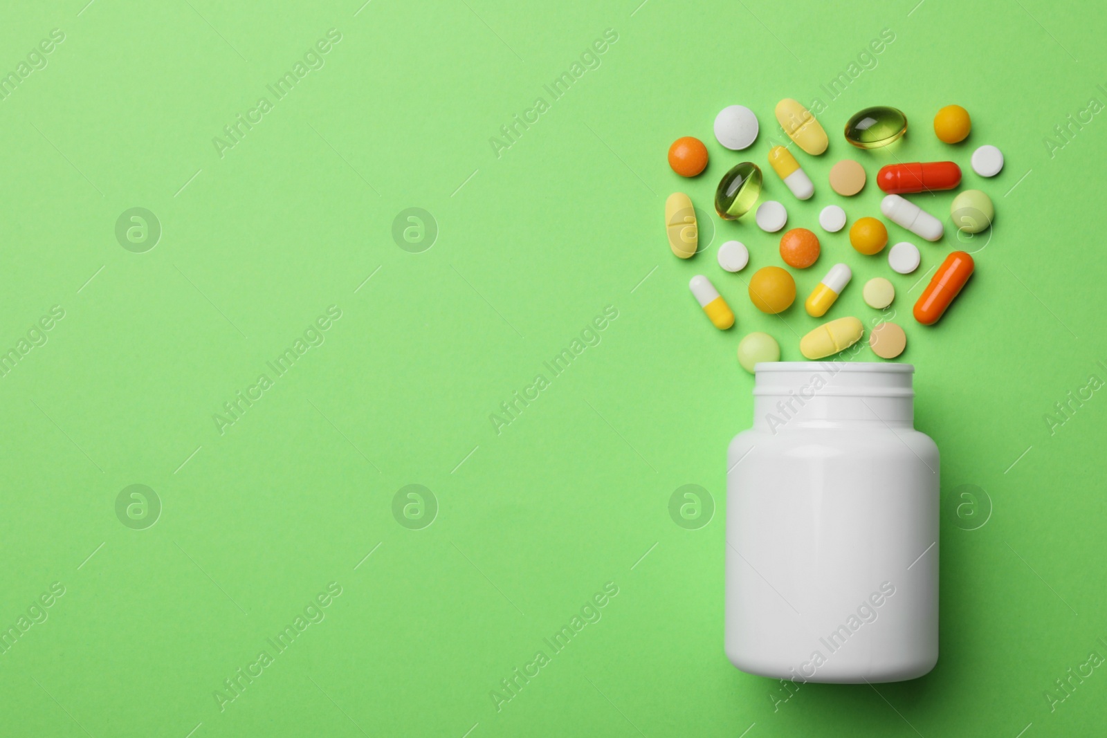 Photo of Bottle with different pills on color background, flat lay. Space for text