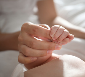 Photo of Mother with her newborn baby, closeup on hands