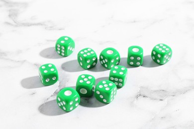 Photo of Many green game dices on white marble table