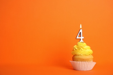 Photo of Birthday cupcake with number four candle on orange background, space for text