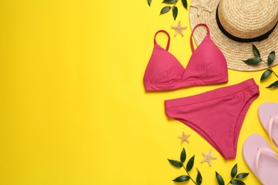 Photo of Stylish bikini and beach accessories on yellow background, flat lay. Space for text