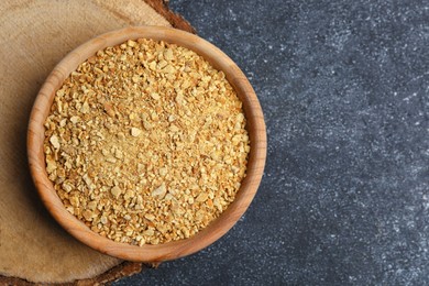 Photo of Bowl of dried orange zest seasoning on grey table, top view. Space for text