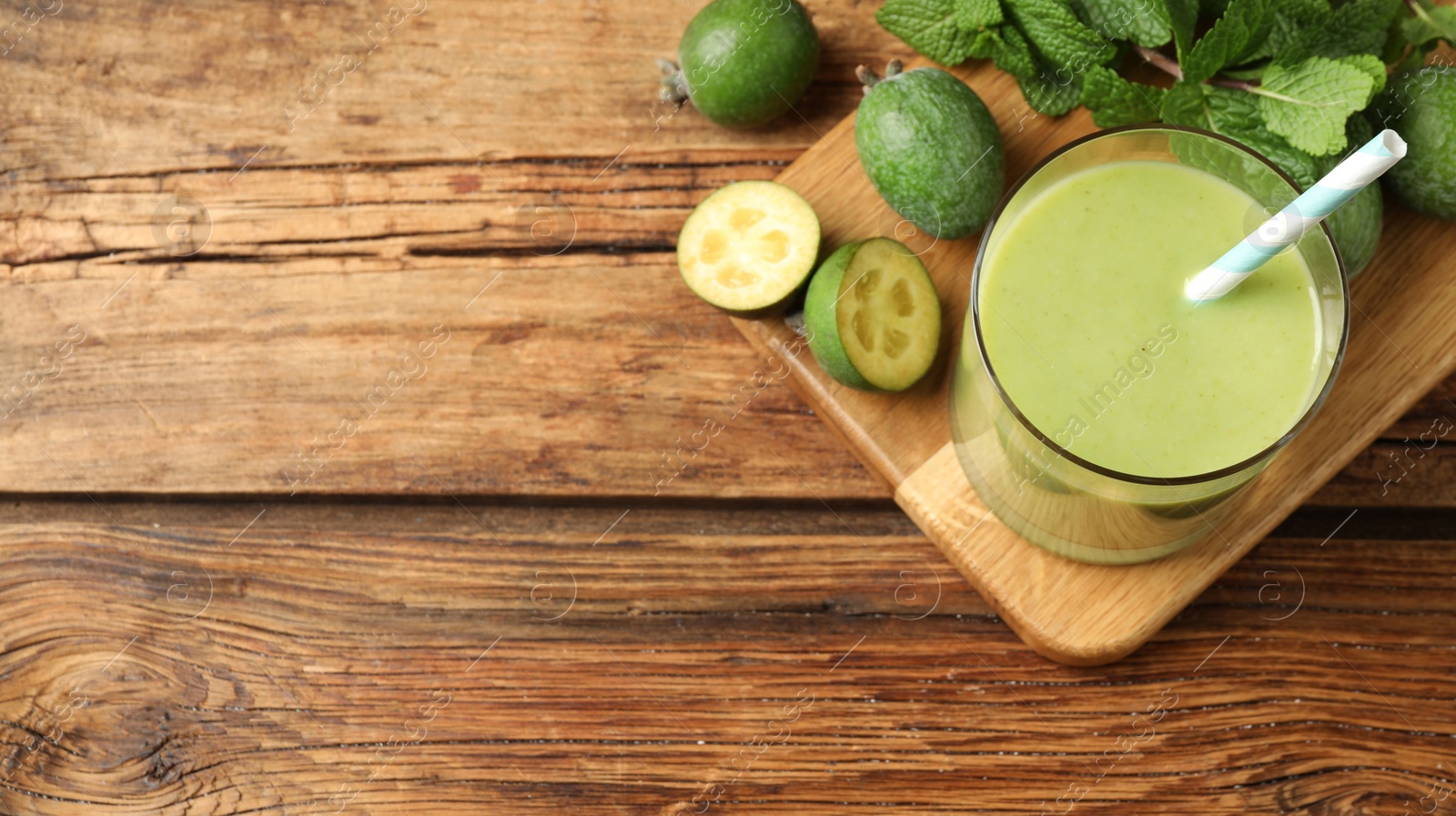 Image of Fresh feijoa smoothie and ingredients on wooden table, flat lay with space for text. Banner design