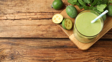 Image of Fresh feijoa smoothie and ingredients on wooden table, flat lay with space for text. Banner design