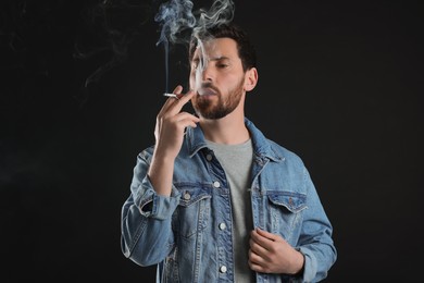 Man using cigarette holder for smoking on black background