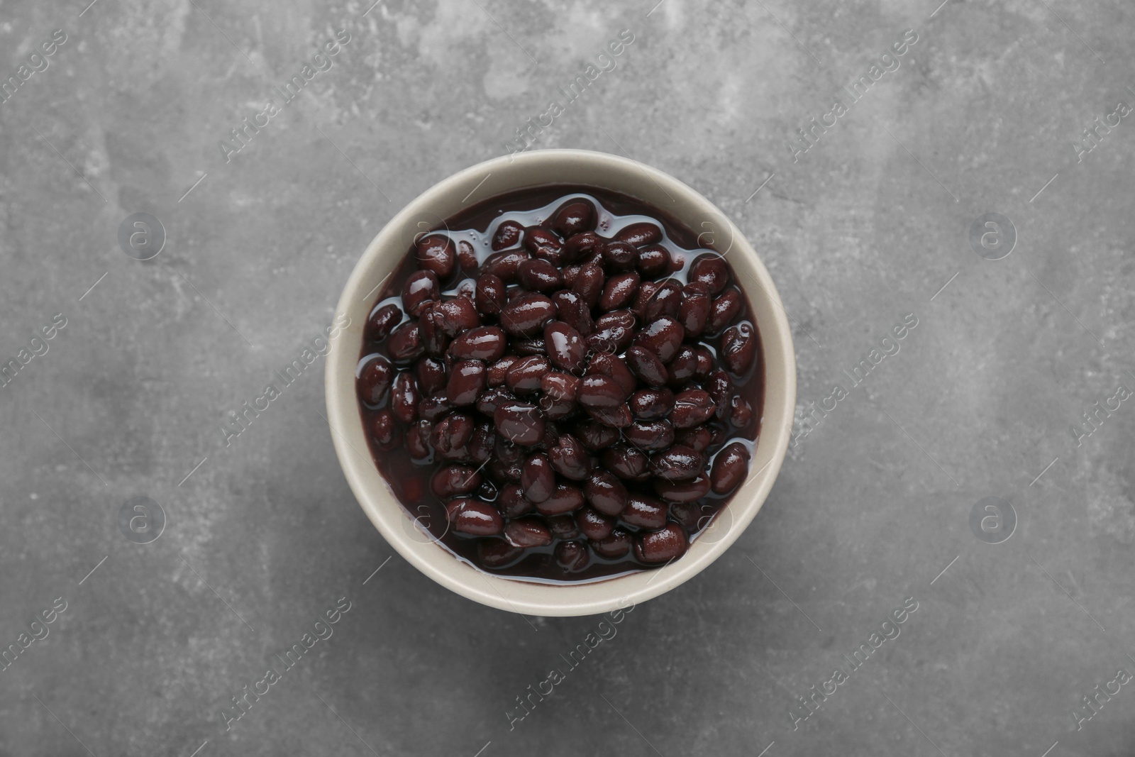 Photo of Bowl of canned kidney beans on grey table, top view