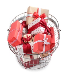 Photo of Shopping basket full of gift boxes on white background