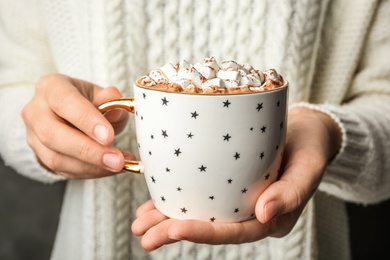 Woman holding cup of delicious hot cocoa with marshmallows , closeup