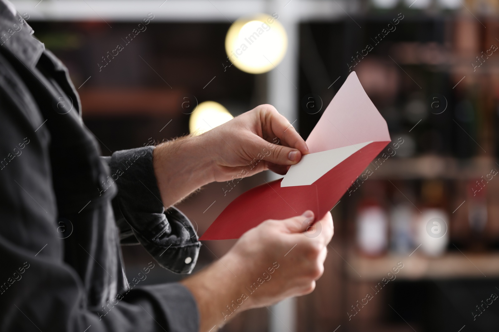 Photo of Man holding envelope with greeting card indoors, closeup