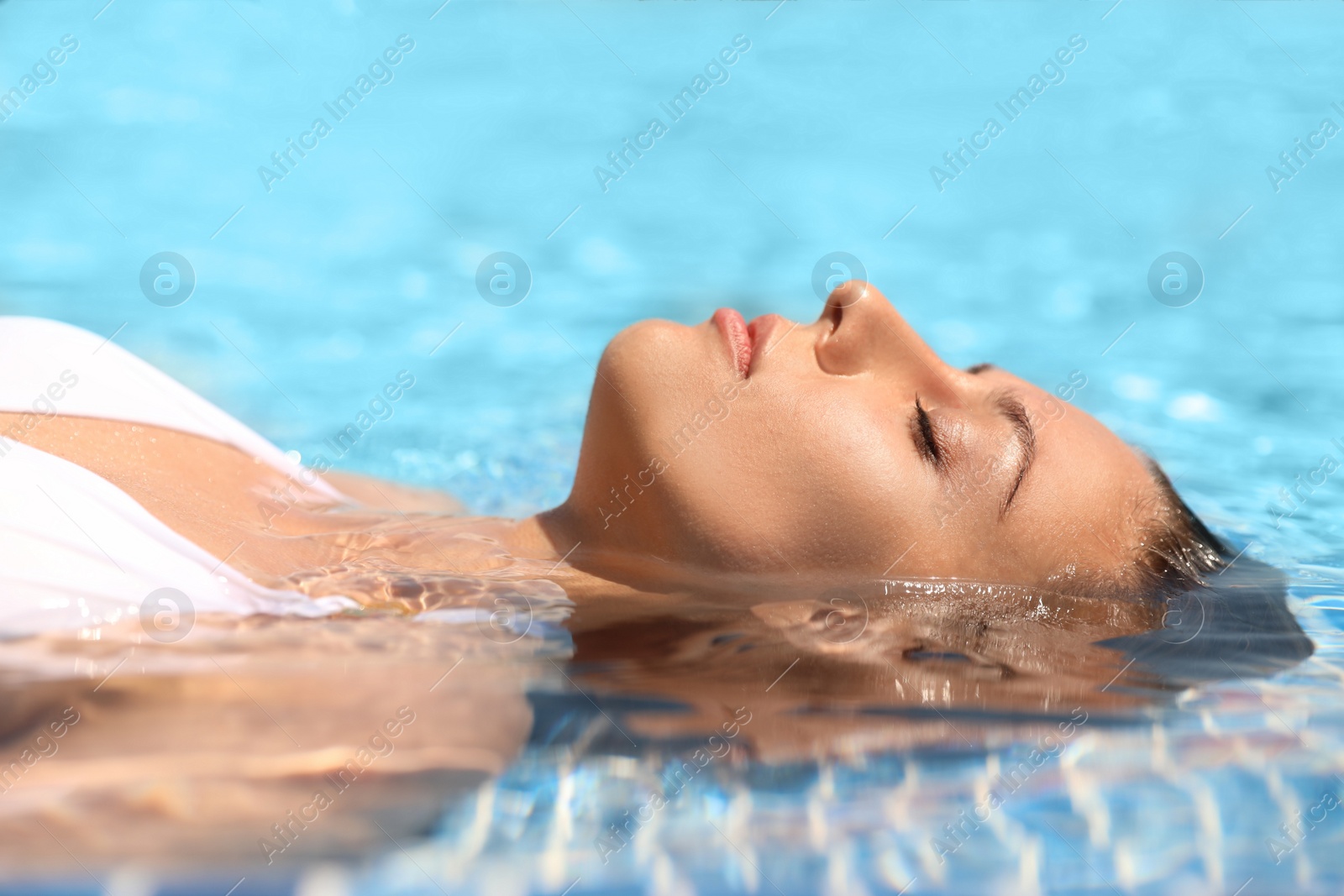 Photo of Beautiful young woman relaxing in outdoor swimming pool