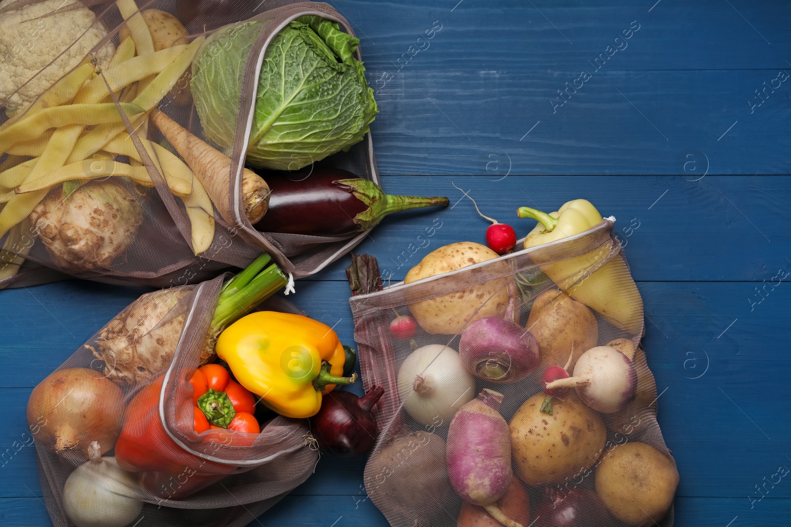 Photo of Different fresh ripe vegetables on blue wooden table, flat lay