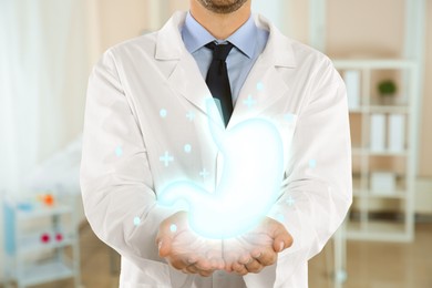 Gastroenterologist holding virtual image of stomach indoors, closeup