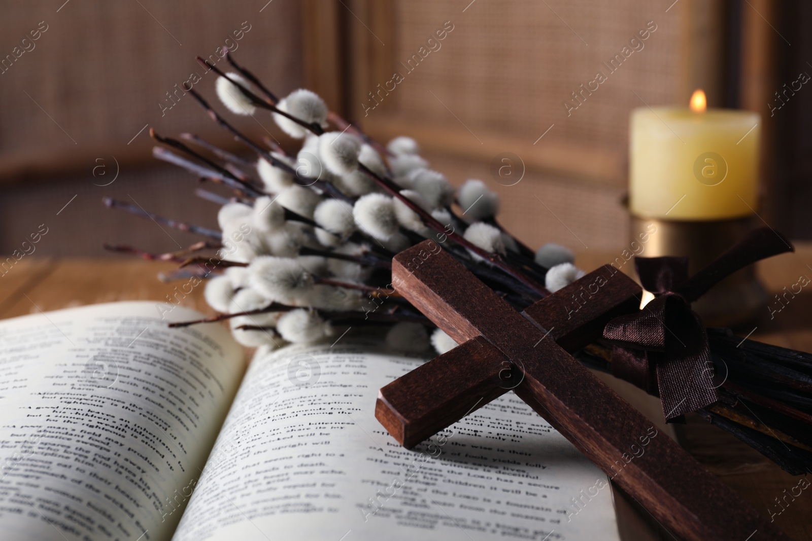 Photo of Wooden cross, Bible and willow branches on table, closeup