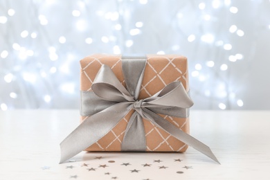 Photo of Christmas gift on table against blurred background