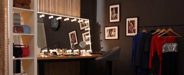 Image of Makeup room. Dressing table with mirror, clothing rack and chair indoors, banner design