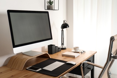 Stylish workplace interior with modern computer on table. Mockup for design