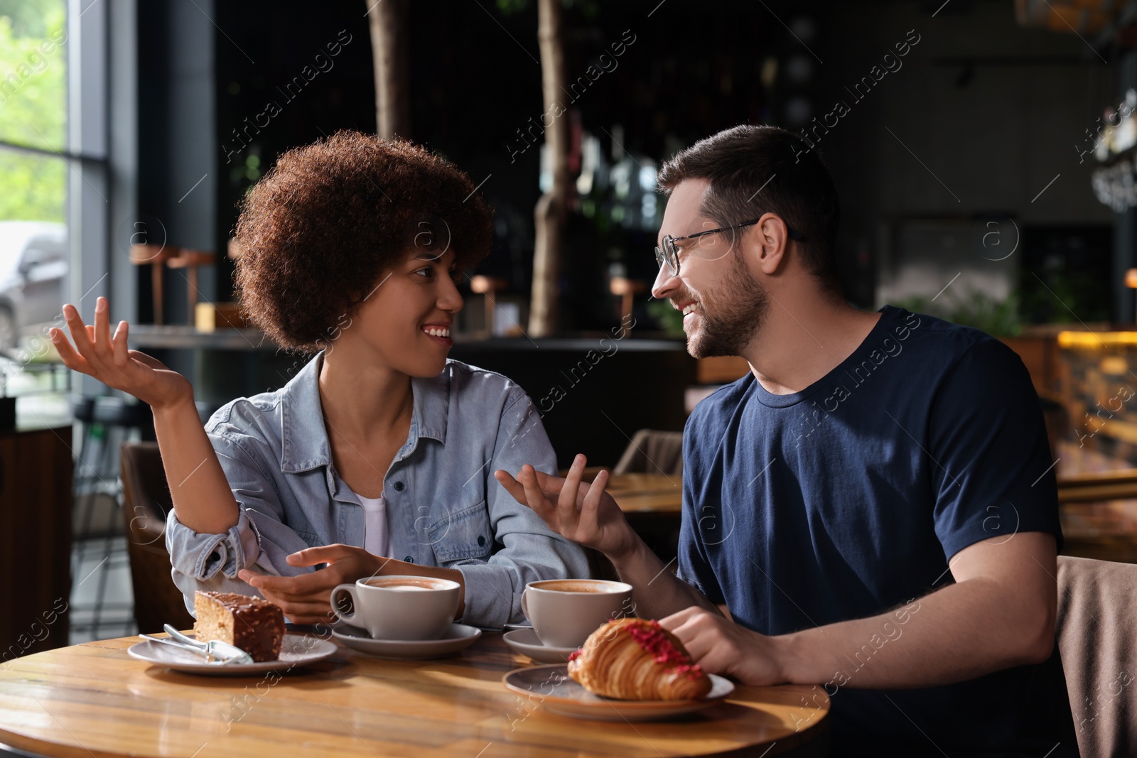 Photo of International dating. Lovely couple spending time together in cafe