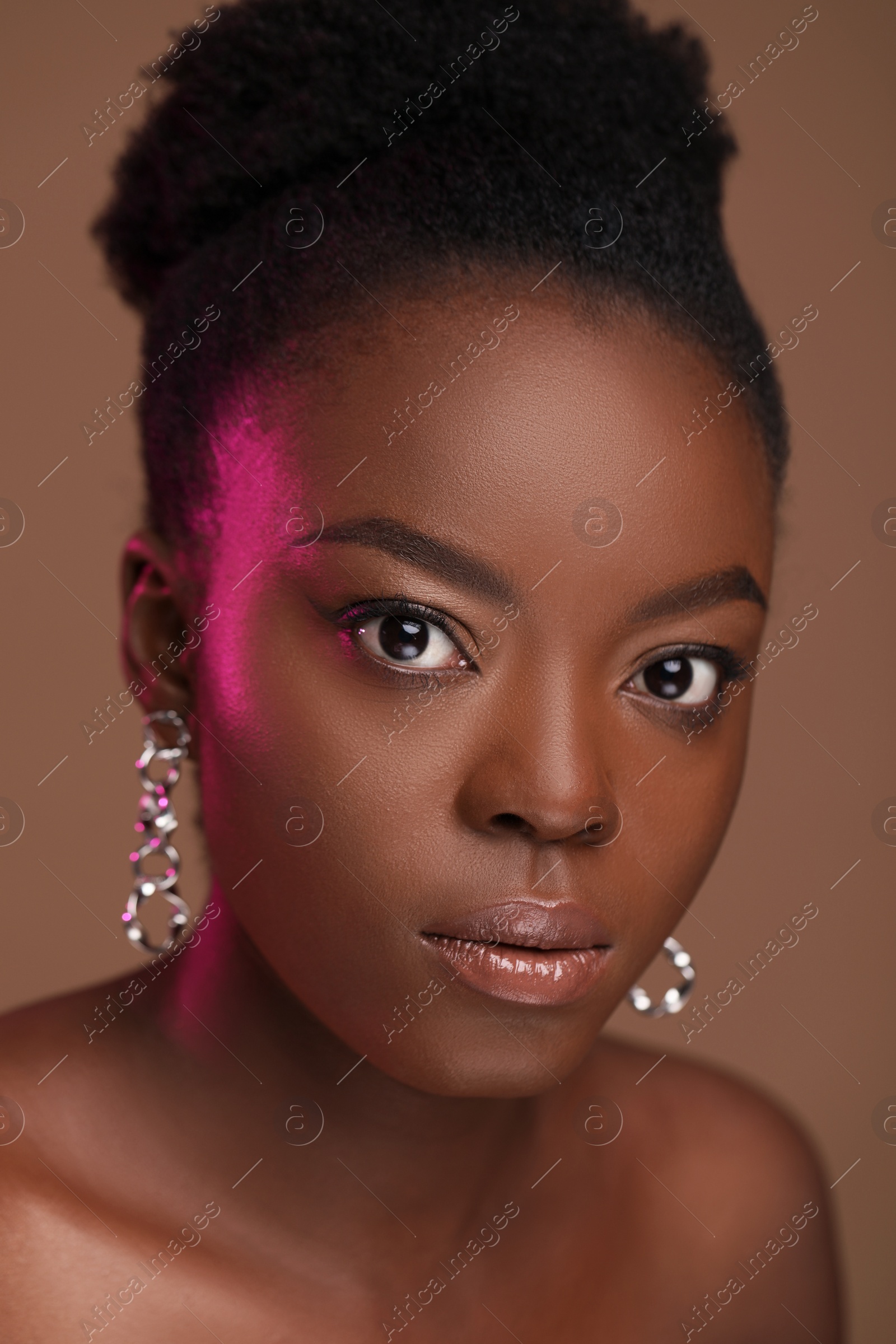 Photo of Fashionable portrait of beautiful woman on light brown background