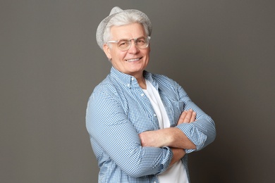 Portrait of stylish mature man against grey background