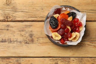 Mix of delicious dried fruits on wooden table, top view. Space for text