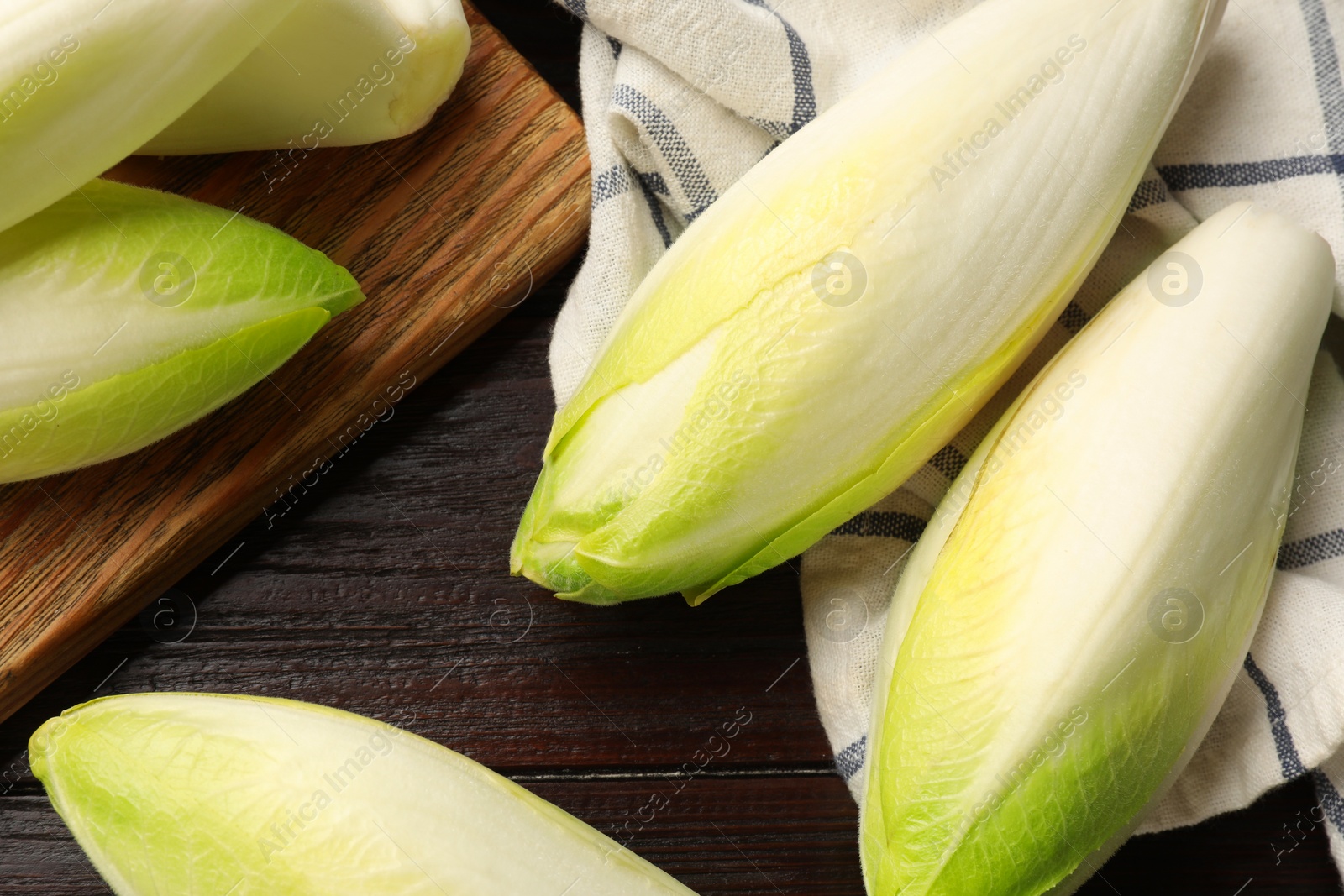 Photo of Raw ripe chicories on wooden table, top view