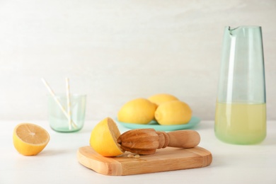 Composition with lemon half and wooden juicer on table