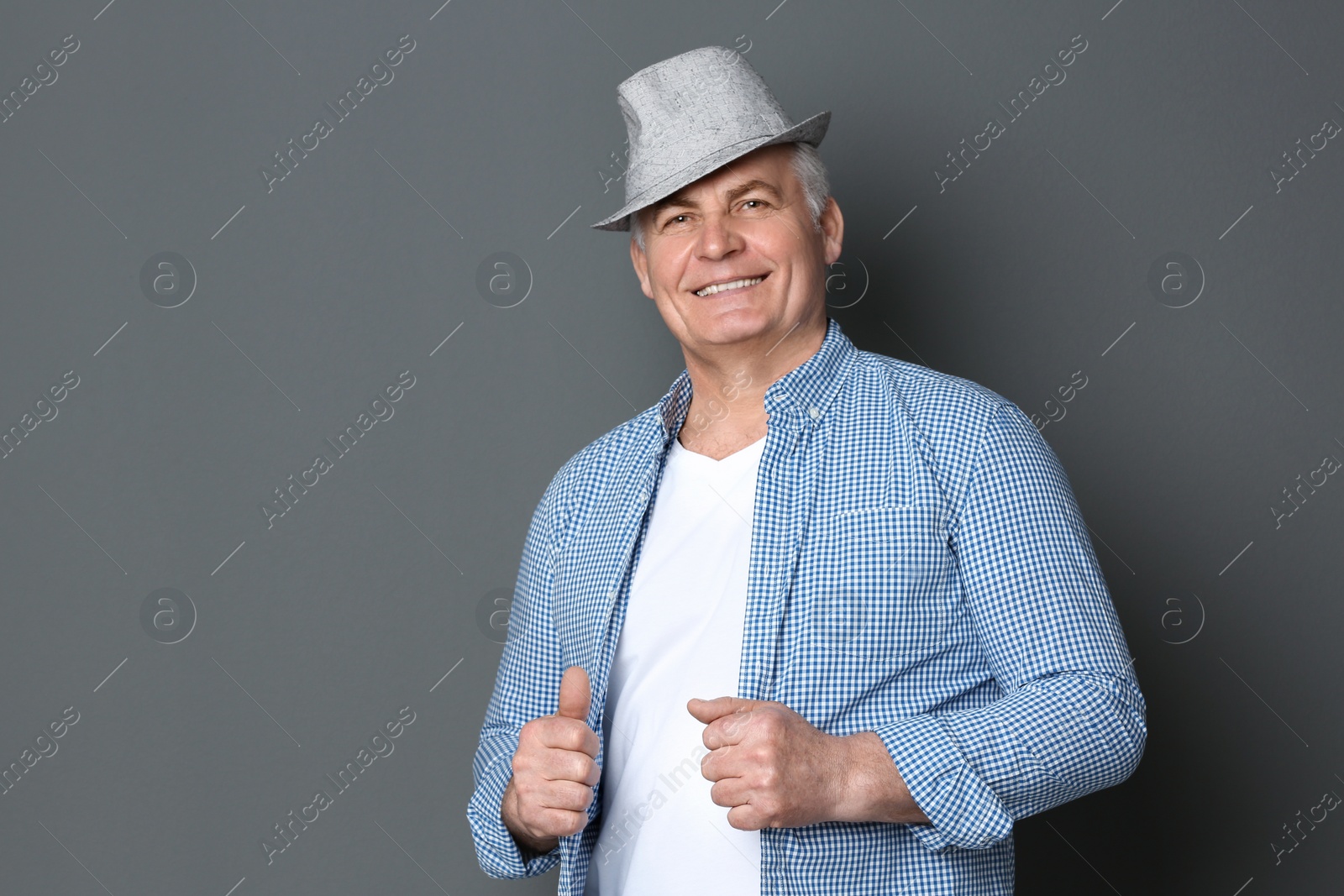 Photo of Portrait of stylish mature man against grey background