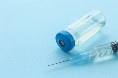 Photo of Vial with vaccine and syringe on color background