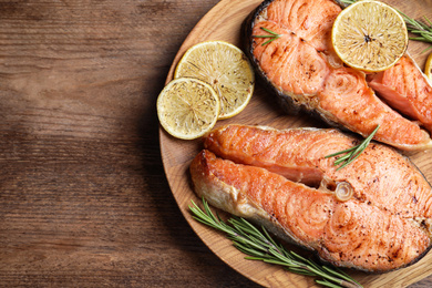 Tasty cooked red fish on wooden table, top view. Space for text