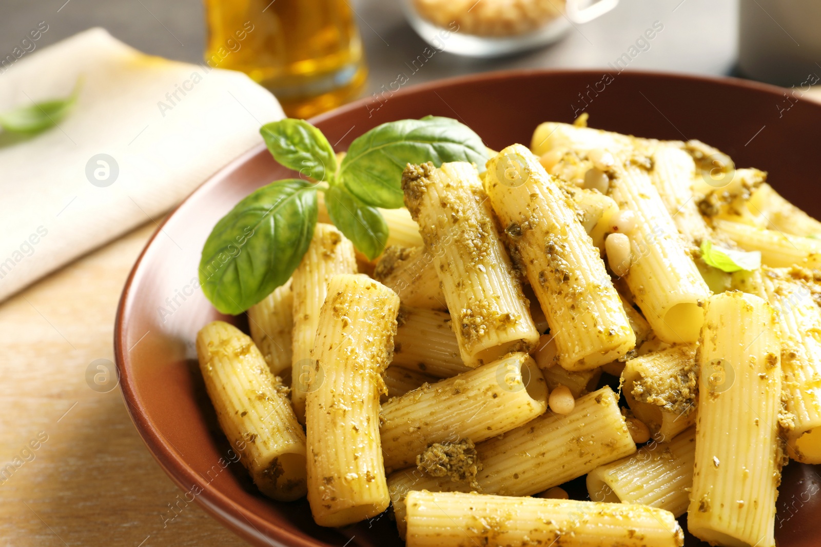 Photo of Plate of delicious basil pesto pasta on table, closeup