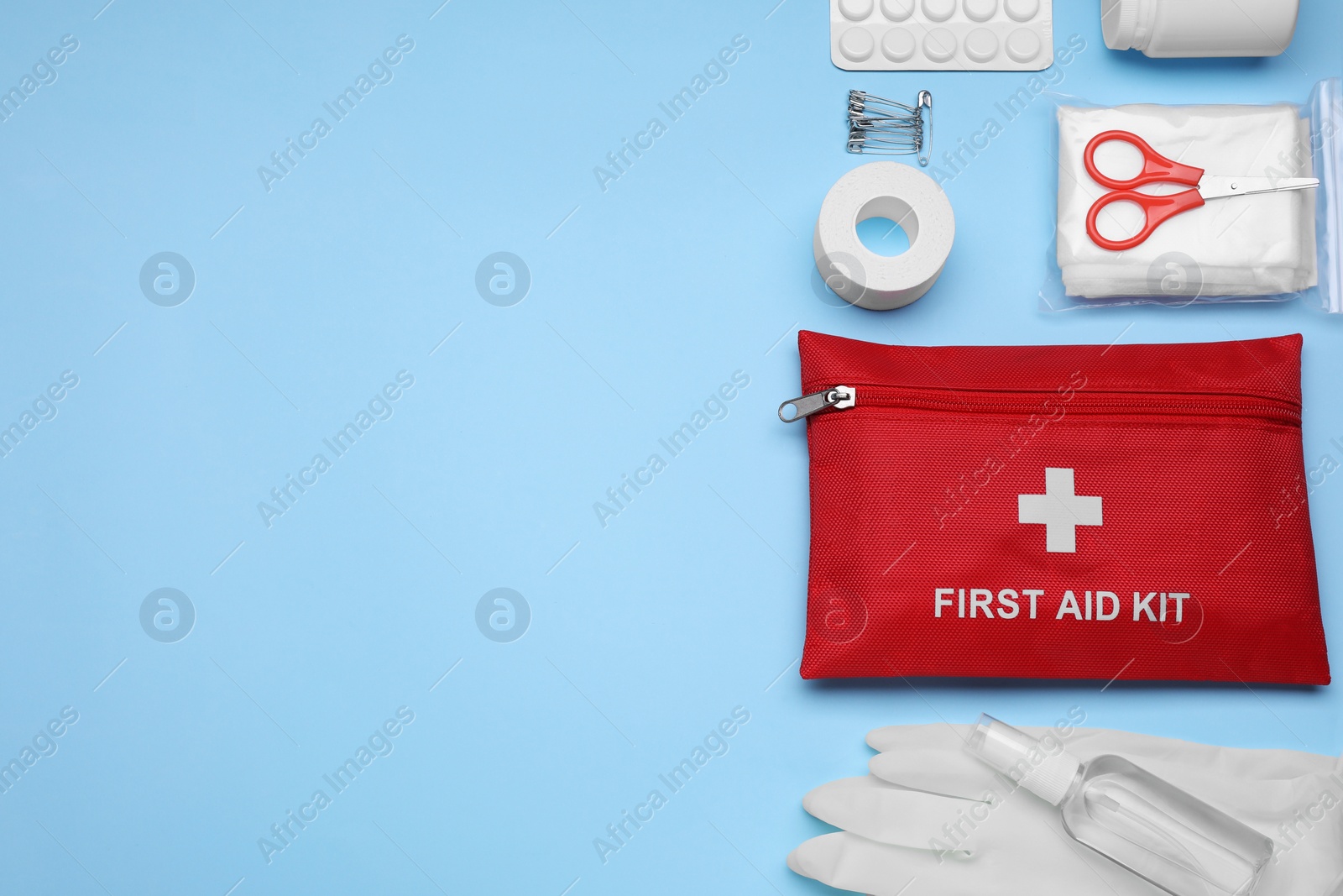 Photo of Flat lay composition with first aid kit on light blue background. Space for text