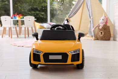 Photo of Yellow car in room at home. Child's toy