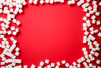 Frame of refined sugar cubes on color background, top view