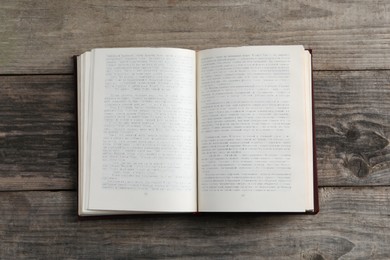 Photo of Open old hardcover book on grey wooden table, top view
