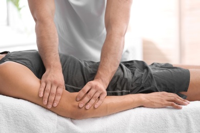 Young man receiving massage in salon, closeup