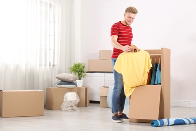 Young man near wardrobe box at home