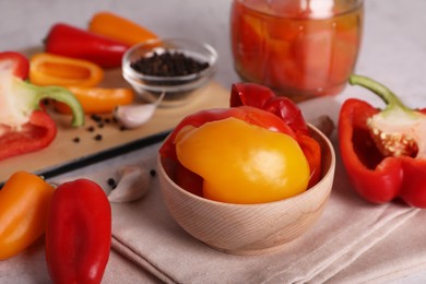 Tasty pickled peppers and fresh vegetables on table