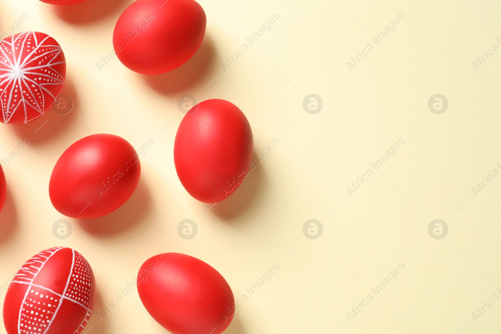 Photo of Flat lay composition of red painted Easter eggs on color background, space for text