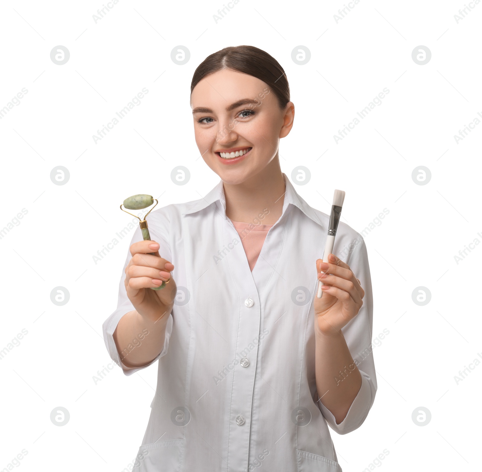 Photo of Cosmetologist with cosmetic brush and facial roller on white background