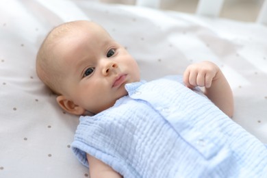 Cute little baby lying in crib at home