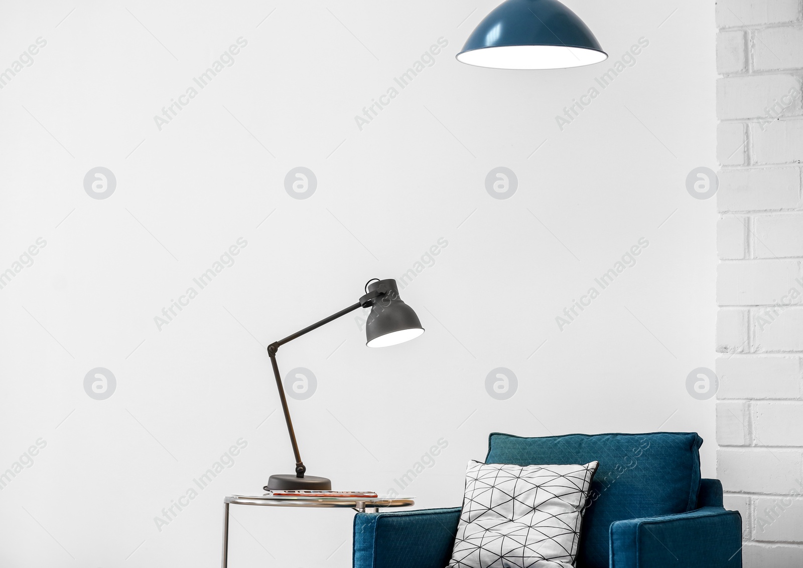 Photo of Modern lamps with blue armchair indoors