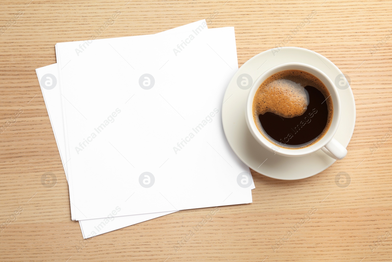 Photo of Blank paper sheets for brochure and cup of coffee on wooden background, flat lay. Mock up