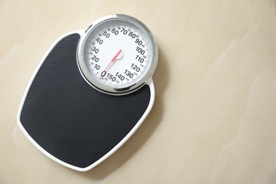 Photo of Top view of scales on tiled floor, space for text. Overweight problem