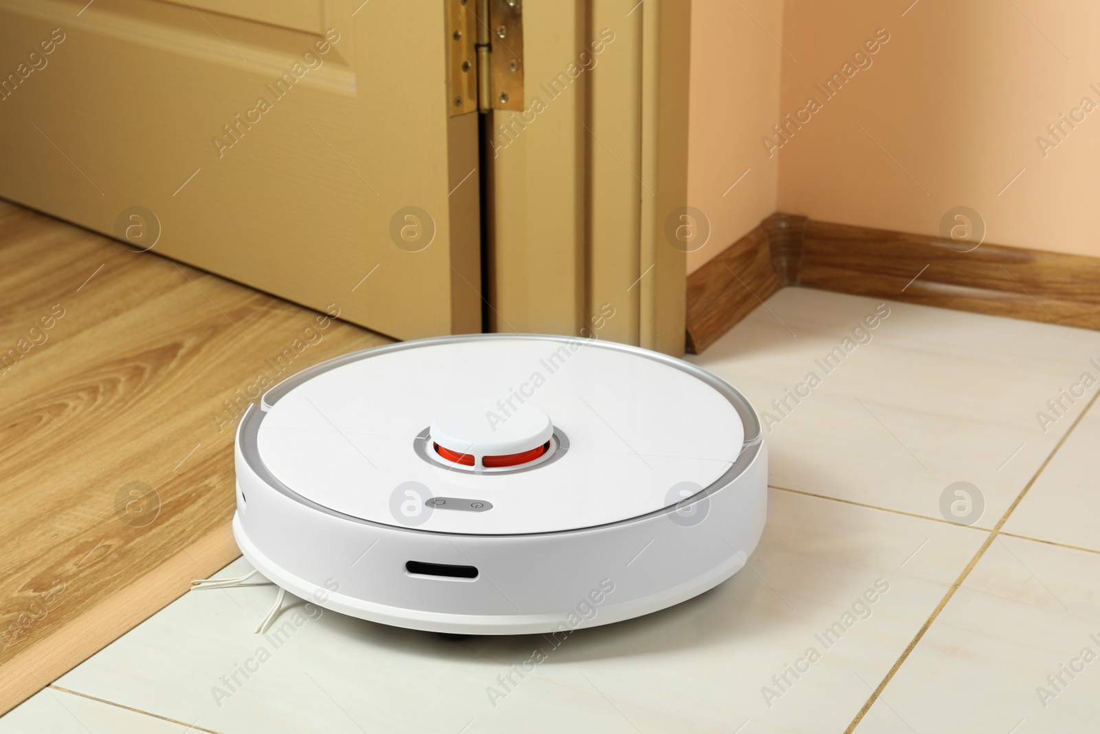 Photo of Modern robotic vacuum cleaner on white floor indoors