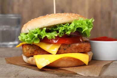 Photo of Delicious tofu burger served with sauce on wooden table, closeup