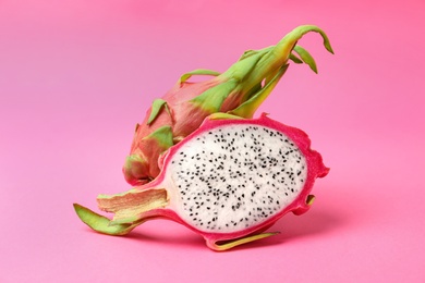 Delicious cut and whole dragon fruits (pitahaya) on pink background