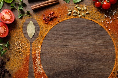 Photo of Silhouettes of plate with spoon made of spices and different ingredients on wooden table, flat lay. Space for text